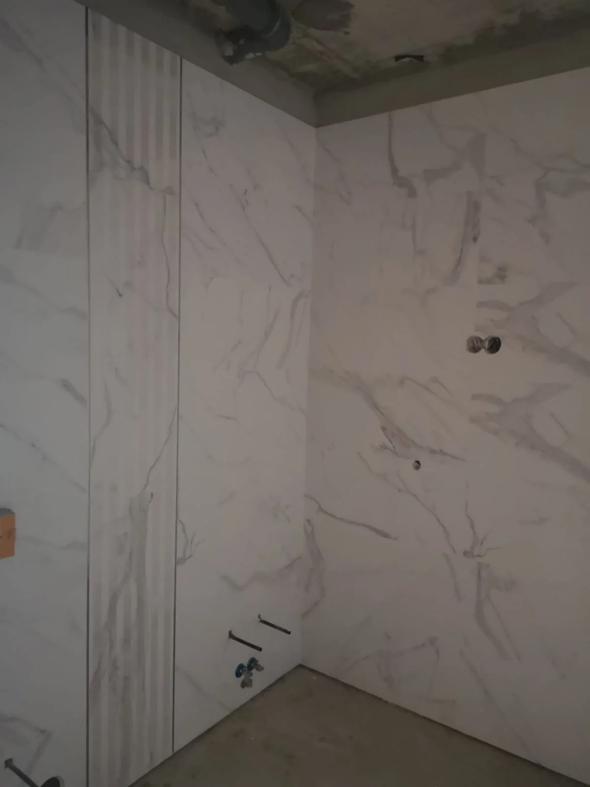 Parede de casa de banho em peças de grande formato com efeito mármore branco